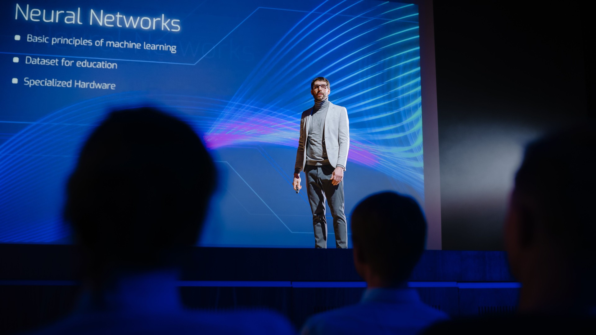 On Stage Speaker Does Presentation of New Product, Uses Remote Control for Presentation, Showing Infographics, Statistics Animation on Big Screen. Live Event / Device Start-up Release